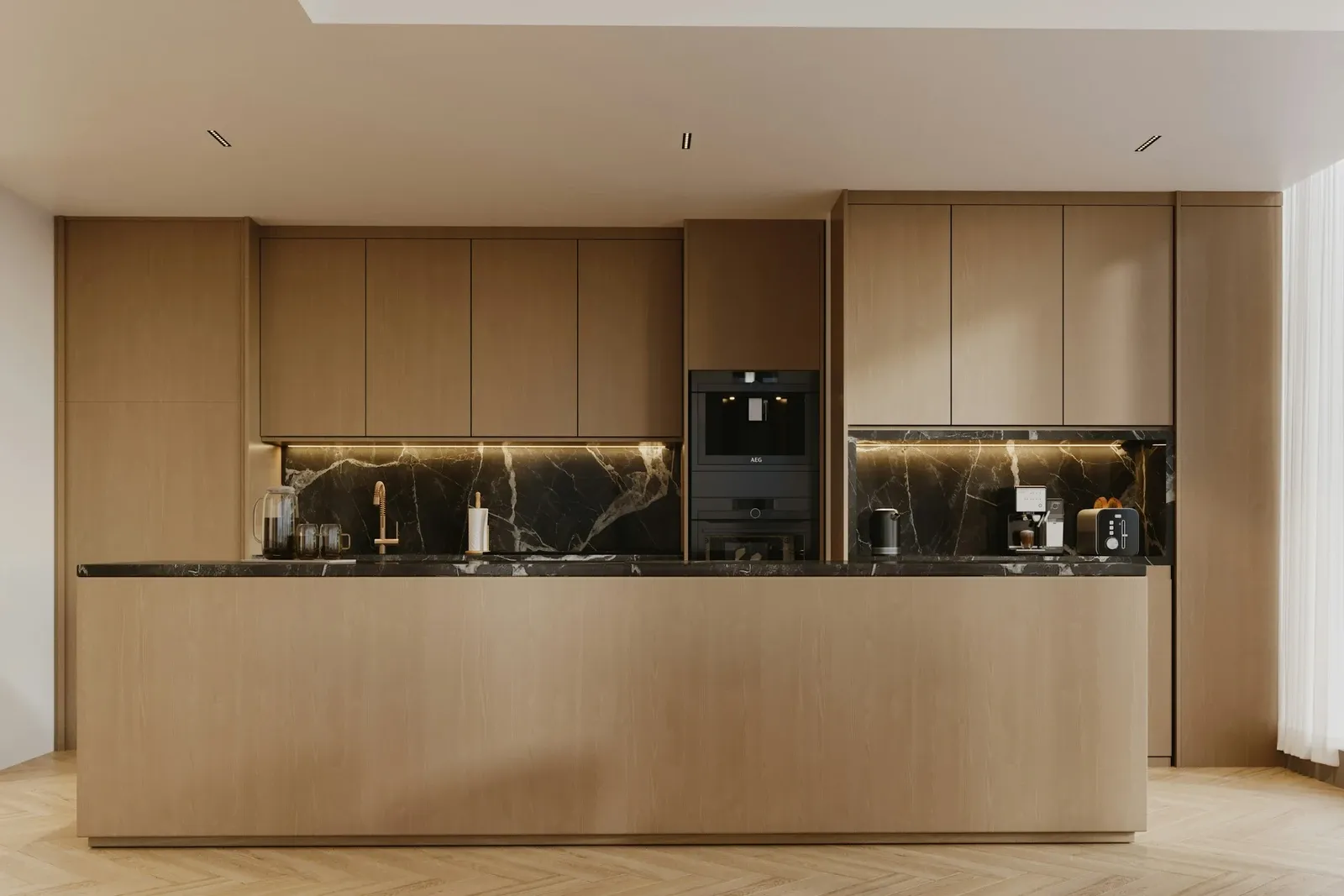 Light wood kitchen with a long island and a wall of built-in cabinets and ovens around a black marble backsplash niche