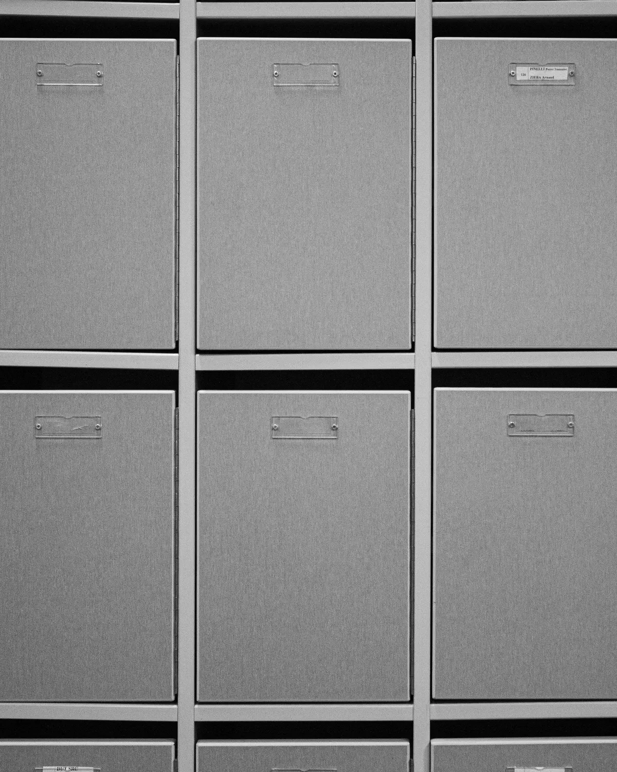 Gray cube shelving unit with matching gray fabric storage bins with label holders in every cube