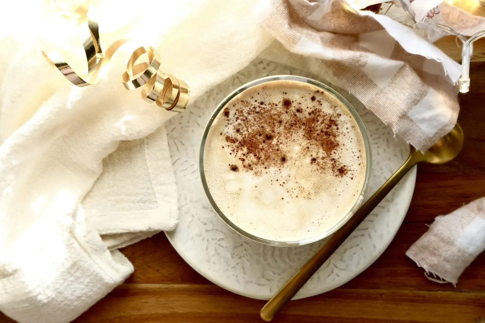 Creamy eggnog latte in a white cup dusted with cinnamon