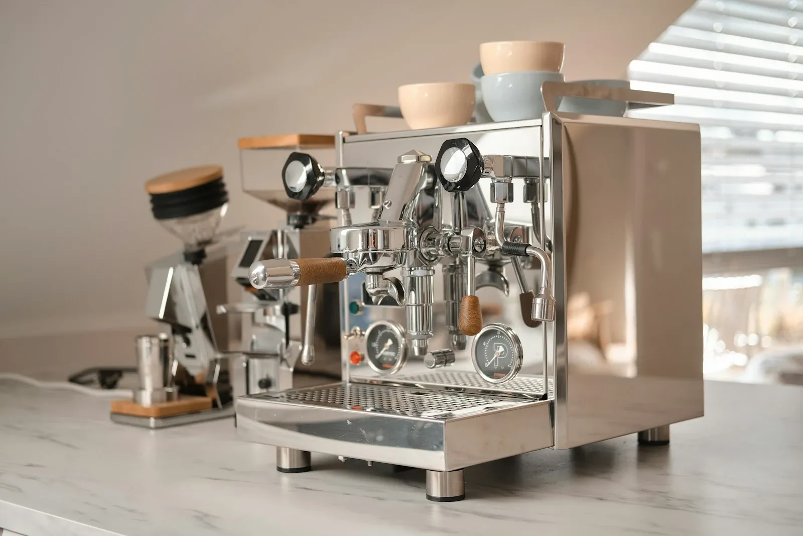 Espresso machine and burr grinder side by side on a marble kitchen counter